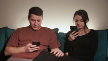 A Couple Sitting on the Couch, Engaged with Their Mobile Phones - Close Up	