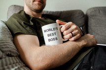 person with a World's Best Boss mug 