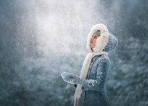 a girl standing in falling snow 