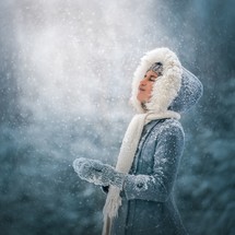 a child standing in falling snow 