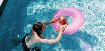 father and infant in a swimming pool 