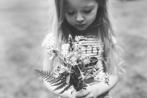 little girl holding a bouquet of picked flowers 