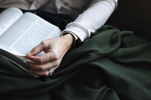 Woman with green blanket reading the Bible
