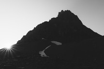 mountain peak silhouette with sunburst 