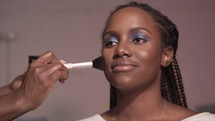 makeup artist applying makeup to a woman 