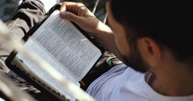 Man reading the bible in a hammock chair