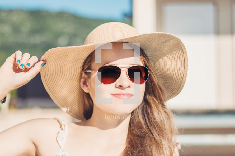a woman in a sunhat and sunglasses 