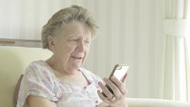Senior caucasian woman using a smartphone themes of retired pensioner technology wifi