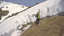Young skier shooting video of avalanche gap in snowy alpine mountains in sunny winter season
