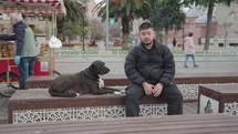 Man and Stray Turkish Street Black Anatolian Shepherd Dog sitting on the bench in Istanbul Istanbul, Turkey