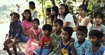 Group of children waving and smiling at the camera in the Philippines