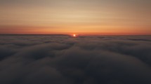 Aerial view above the clouds during sunrise