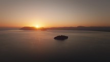 Scenic aerial view above the sea with islands and mountains in the background during sunset on the horizon