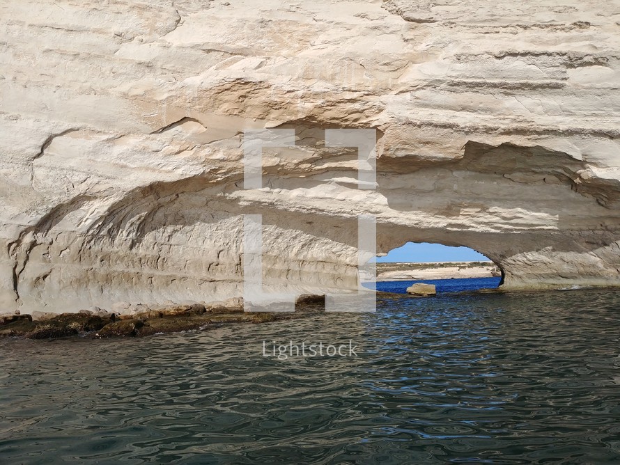 cave opening in rock over water