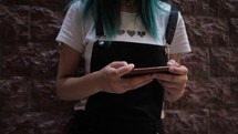 Woman with blue hair texting on her phone 