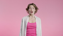 Surprised woman, she expresses WOW, cant believe. Impressed lady trying to get attention. Concept of sales, profitable offer. Excited romantic girl on pink background. High quality 