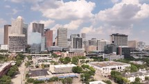 Aerial video of downtown Houston, Texas on a beautiful blue sky cloudy day with tall buildings in the background.