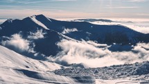 Misty mountains clouds time-lapse in cold sunny winter season in alps nature landscape
