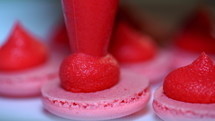 Making pink macarons, squeezing and adding cream filling from pastry bag. Macaroons - delicious and beautiful french dessert. Cooking, food and baking, pastry shop concept