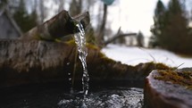 Clear drinking water flows from a spring in a mountain well
