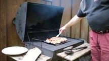 man cooking on a grill 