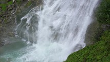 Waterfall in green nature of Tirol alps, slow motion
