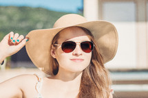 a woman in a sunhat and sunglasses 