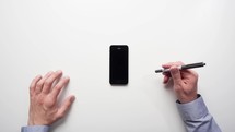 Timelapse personal perspective of a man putting post it notes onto a smartphone themes of overworked planning brainstorm