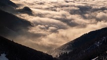 Beautiful morning sunrise light in misty mountains valley with foggy clouds motion in peaceful sunny nature landscape Time -apse
