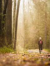 Woman walking on path in forest