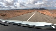 Fast driving on the road trip in desert Moroccan landscape in sunny summer time-lapse
