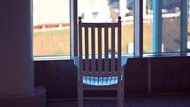 Rocking chair in front of a window.