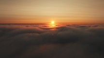 Sun rises above heavenly clouds