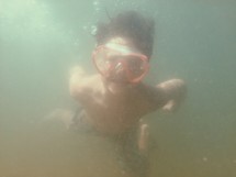 a boy child swimming under water 