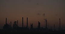 silhouette of a large scale oil refinery during sunrise