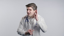 Interested physician man in white medical coat form asks WHAT, not hear. Whisper quiet sound. Hearing, loss and deaf, problems with misunderstanding. High quality 4k footage