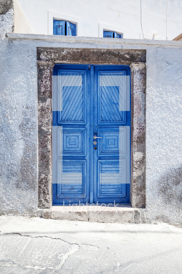 blue gate doors to a white wall 