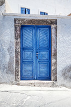 blue gate doors to a white wall 