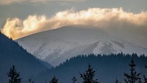 Clouds moving over snowy peak in winter mountains nature Time-lapse
