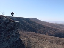 Person jumping off a cliff.