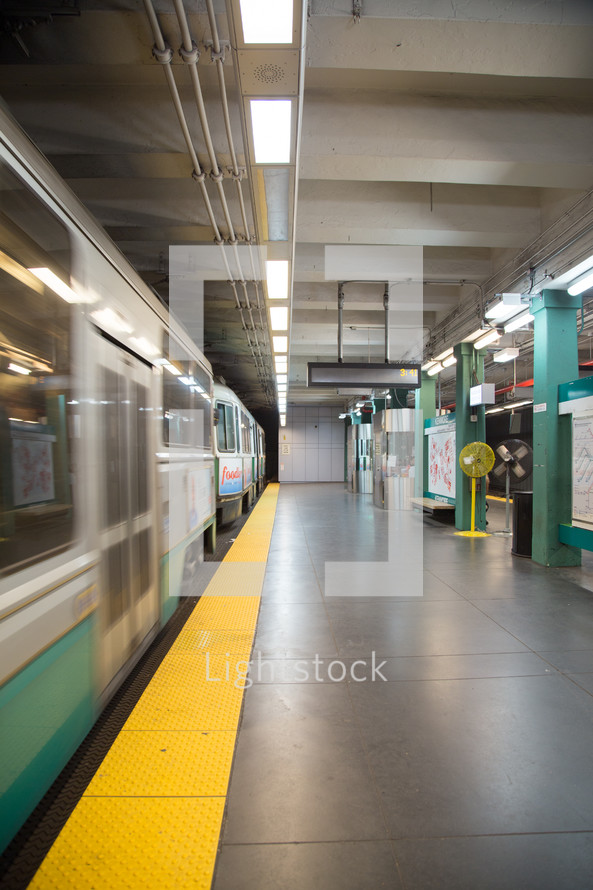 An empty subway station platform next to a subway train.