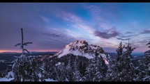 Clouds motion fast over rocky peak in frozen winter alps mountains forest at sunrise Time lapse Nature
