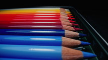 Crayons in perfect gradient row. Rainbow instruments for children, students, designer, artist drawing. Back to school. Extreme macro slider dolly footage colored graphite pencils set.