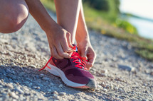 a woman tying her shoe laces before a jog