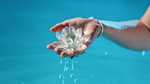 Woman holding fragile lotus flower. Clean water drops are dripping from crystal. Concept of religion, kundalini, meditation, chakras, spiritual inner world. High quality 4k footage