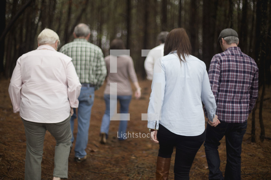 A couple and friends walking through the woods.