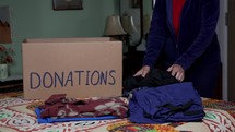 A woman putting clothing into a box for donations