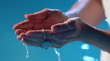 Clean stream of water pours into woman's palm