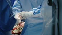 Surgeons working during open heart surgery, close up on hands and instruments.