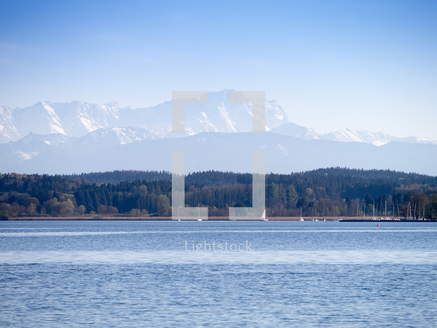 sailboats on a lake with mountains in the background 